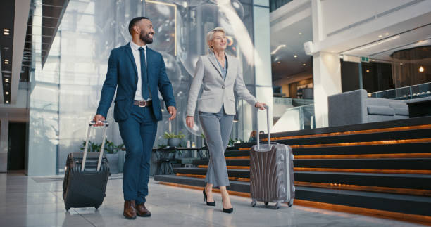 Business travelers walking through a hotel lobby with luggage